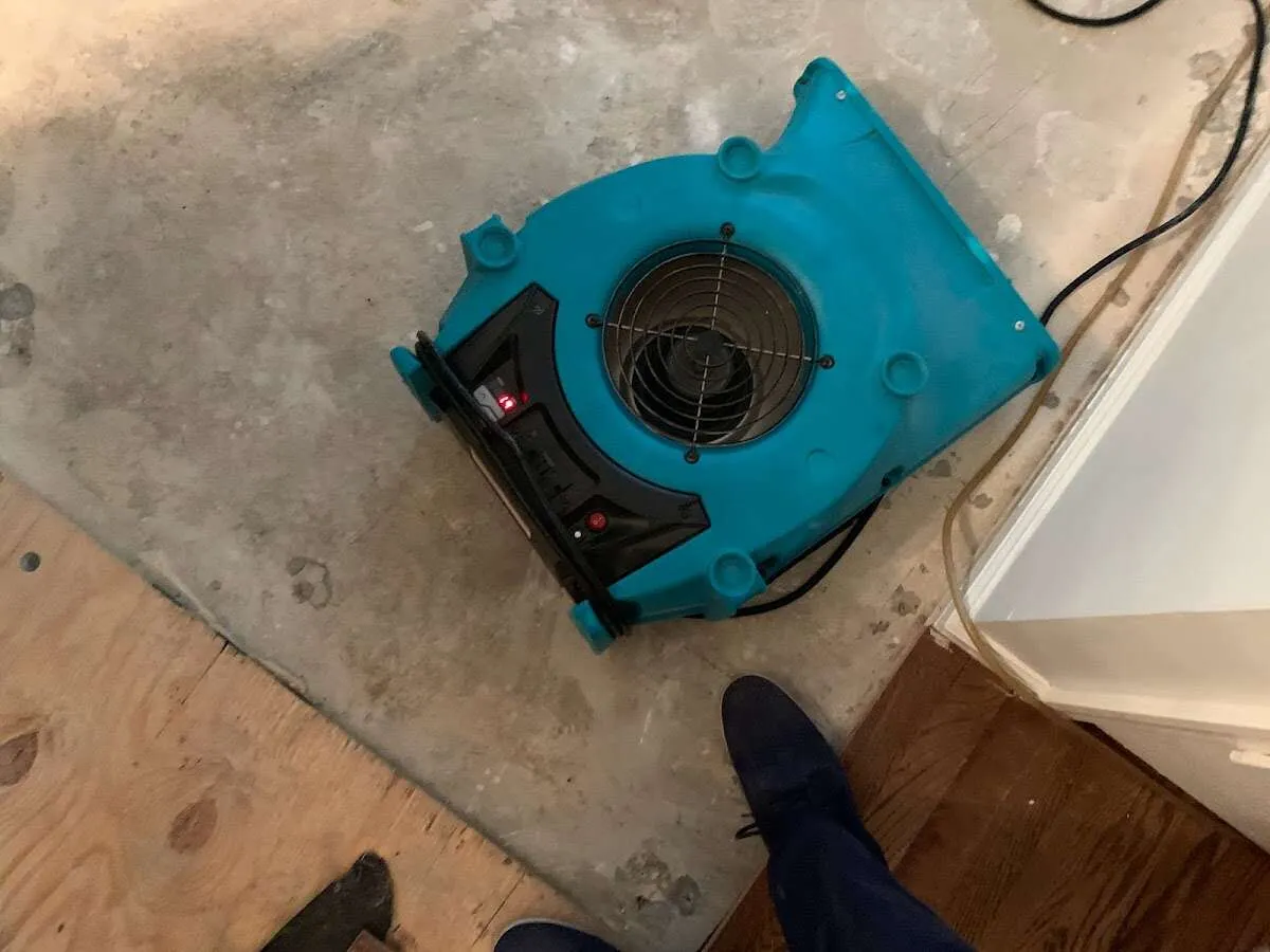 Air mover drying subfloor during Commercial Water Damage Restoration in Itasca